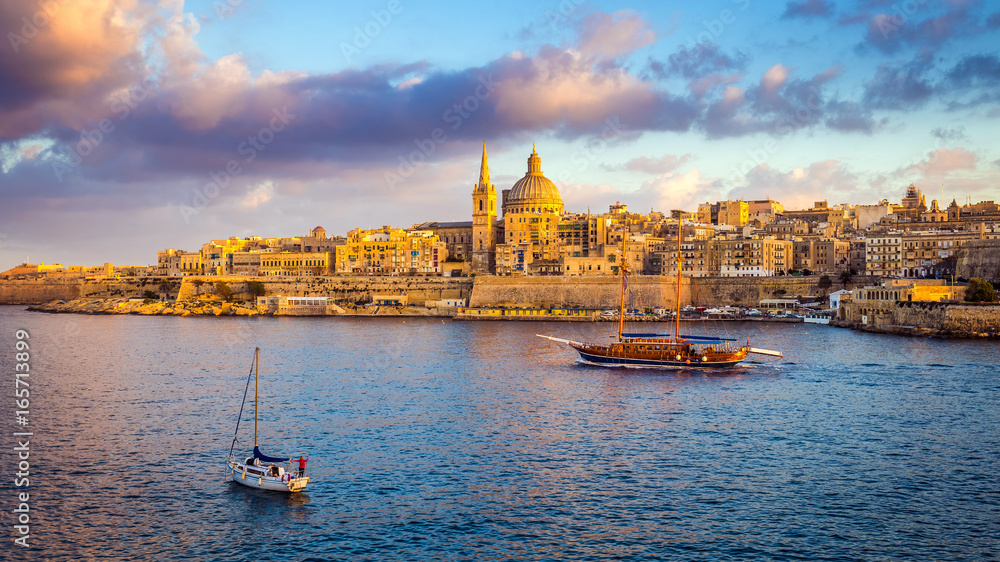 Obraz na płótnie Valletta, Malta - Sail boats at the walls of Valletta with Saint Paul's Cathedral and beautiful sky and clouds in the morning w salonie