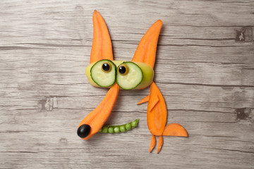 Funny vegetable fox made on wooden background