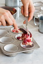 Making Raspberry Muffins Or Cupcakes: Hands Dropping Batter Into Tins