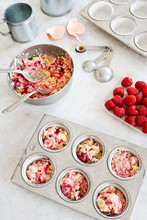 Making Raspberry Muffins Or Cupcakes: Batter In Tins And Ingredients On Countertop