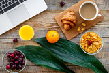 Fototapeta Koty - French breakfast. Fresh croissant, coffee, muesli, oranges, cherry on wooden table background top view