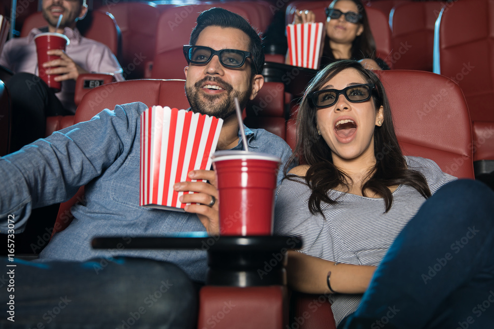 Surprised couple watching a 3d movie - obrazy, fototapety, plakaty 