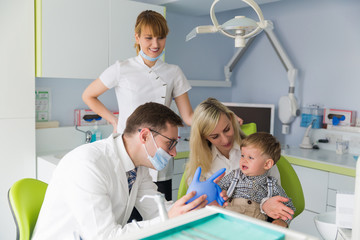 Wall Mural - .Friendly dentistry works with a child in a clinic