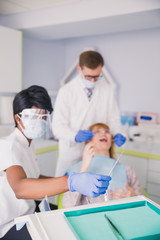 Wall Mural - A dentist with an assistant treats the patient