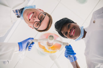 Wall Mural -  dentists in protection gloves and a mask, keeps dental instrument looking at the camera.