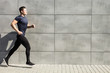 © Andrii Zastrozhnov - A young man runs against a gray wall, urban.