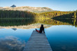 Girl Sitting on dock enjoying the mountains and morring light