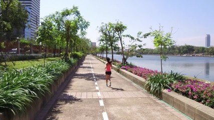 Wall Mural - Woman running in benjakitti park 