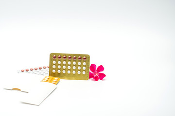 Wall Mural - Contraceptive pills with pink flower on white background