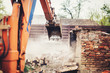 © aboutmomentsimages - industrial close up of excavator using scoop for demolishing old house and ruins