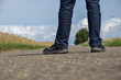 A man is standing on the road. Legs close-up.