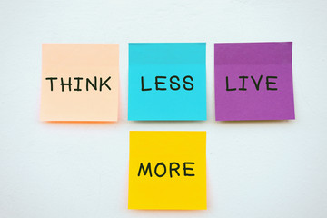 Wall Mural - Think less live more - Inspirational and motivation quotes on colorful sticky paper on a wall, pastel colors.