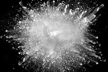 Freeze Motion Of White Dust Explosion On Black Background. Stopping The Movement Of White Powder On Dark Background. Explosive Powder White On Black Background.