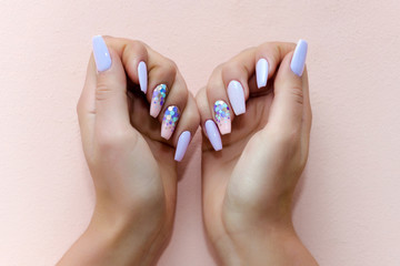 Woman show professional manicure on pink background.