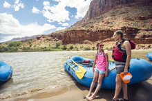 Smiling Child And Adult Women Ready To Board A Large Inflatable Raft As They Travel Down The Scenic Colorado River Near Moab, Utah And Arches National Park