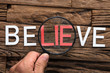 Hand Holding Magnifying Glass Over Word Lie In Believe
