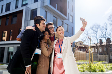 Wall Mural - happy people with conference badges taking selfie