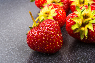 fresh ripe strawberries on black ceramic plate