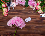 Fototapeta Tulipany - Beautiful flowers, scissors and accessories on table, Florist desktop with working tools