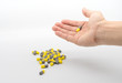 © v74 - Woman hand holding yellow and gray capsule medicines