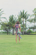 © belart84 - Woman walking barefoot on a tropical green field. Bali island, Indonesia. Nusa Dua park.