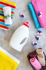 Wash clothes. Clean towel and detergent on grey stone background top view