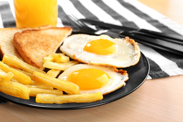 Tasty breakfast with fried eggs on table