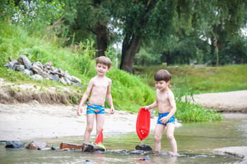 Wall Mural - two blond brothers are having fun on the beach in a sunny summer day