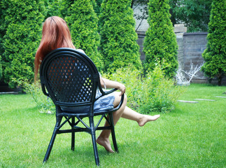 Canvas Print - Young girl sitting on comfortable chair in park