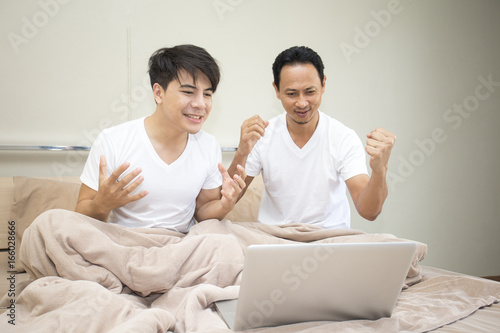 500px x 334px - Man and friend watching porn movie with laptop in bedroom ...
