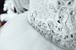 Part of white bridal dress with shining rhinestones. The waist of the bride. Wedding bodice. Close-up