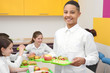 © Africa Studio - Cute boy holding tray with delicious food in school canteen