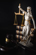 Legal code, enforcement of the law and blind Iustitia concept with statue of the blindfolded lady justice ( Dike in Greek and Justitia in Roman mythology), a stack of books and a gavel