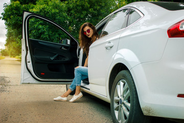 glamorous Lady with glasses sits in a big beautiful white car