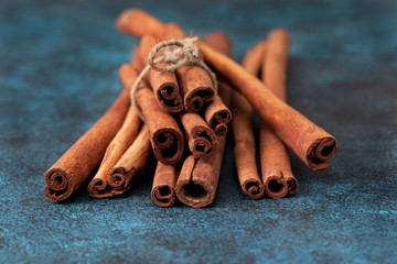 Wall Mural - Cinnamon sticks on blue background. Dark