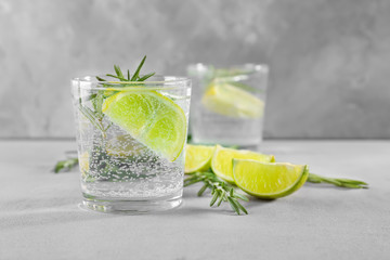 Wall Mural - Glass of fresh lime lemonade with rosemary on grey background