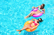 © Africa Studio - Beautiful young women with inflatable rings in blue swimming pool
