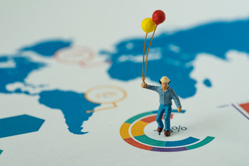 happy business concept as miniature man holding balloons standing at the center of analysis infographic circle chart paper