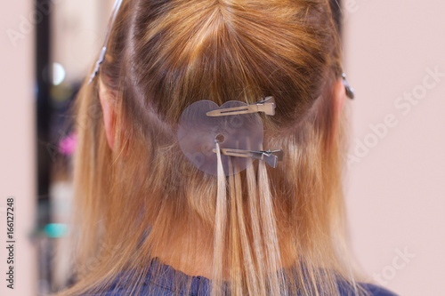 The Hairdresser Does Hair Extensions To A Young Girl A Blonde In A Beauty Salon Professional Hair Care Kaufen Sie Dieses Foto Und Finden Sie Ahnliche Bilder Auf Adobe Stock