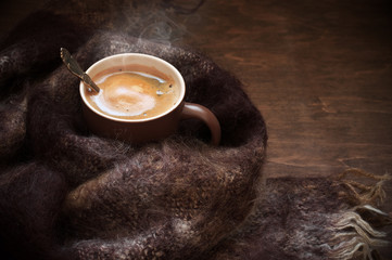 Hot coffee in warm scarf