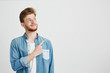 © Cookie Studio - Portrait of cheerful young handsome man smiling pointing finger up over white background.