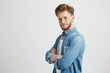 © Cookie Studio - Portrait of confident young handsome man smiling looking at camera with crossed arms over white background.