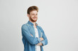 © Cookie Studio - Portrait of cheerful confident young handsome man with beard smiling over white background. Crossed arms.