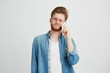 © Cookie Studio - Portrait of young handsome guy with beard disagree speaking on phone over white background.