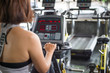 © luvvstudio - Young beautiful woman treadmill machine control in fitness gym