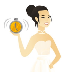 Wall Mural - Young asian fiancee holding an alarm clock.