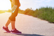 © Sviatoslav Kovtun - Girl holds sports bottle with water for drinks, legs and sneakers, sunlight
