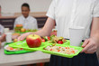 © Africa Studio - Girl holding tray with delicious food in school canteen, closeup