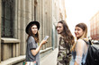 © shurkin_son - Three happy tourists best friends walking along street of old town, sightseeing during holidays in foreign country. Two women and man wearing stylish clothes spending nice time together on summer day