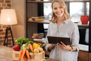 Wall Mural - Active savvy lady using her tablet in the kitchen